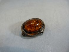 Art Nouveau silver brooch set with Amber cabochon.