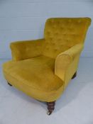 Antique Edwardian button back armchair on oak legs with castors