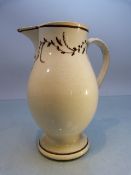 18th Century Staffordshire creamware jug of tall form. Brown banding to rim and foot. With simple
