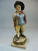 Staffordshire pearlware figure of a young boy dressed in overcoat and black hat emblematic of