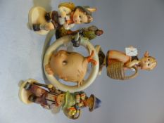 Selection of Goebel Hummel figures along with a Circular wall plaque depicting a baby looking at a
