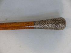 Walking cane - possibly Maple/Walnut mounted with silver coloured metal top of Rococo scrolls and