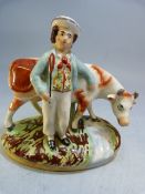 Early 19th Century staffordshire figure group of a boy and his cow, one hand on the cow shoulder,