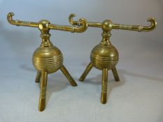 A Pair of Christopher Dresser Brass Globular Fire Dogs on Tripod Feet, both stamped 11 to base