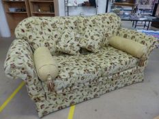 Floral upholstered beige ground three seater sofa