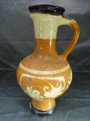 Slipware terracotta colour jug with red and cream decoration in the form of simplistic flowers,