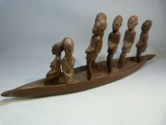 African carved canoe with standing people.