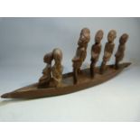 African carved canoe with standing people.