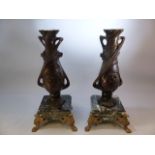 C Bonneford french Art Nouveau bronzed candlesticks on marble plinths with gilt feet.