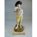 Staffordshire pearlware figure of a young boy wearing top hat, holding grapes above a vessel