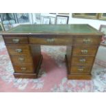 Oak Leather inset 19th Century kneehole pedestal desk with brass handles on plinth feet.