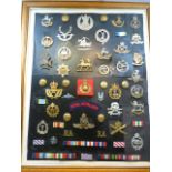 A collection of Cap Badges & insignia attached to a black background and framed approx 50 items