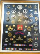 A collection of Cap Badges & insignia attached to a black background and framed approx 50 items