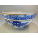 A Chinese bowl decorated in Blue and White with flowers and a two men in a sailing boat with a