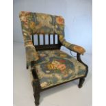 Ebonised nursing chair with upholstered open arms and splat back. Architectural column type legs.