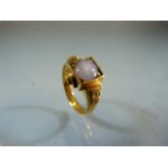 Gold ring unmarked but testing as 18ct or above set with a single stone (possible Moonstone). Size