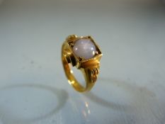 Gold ring unmarked but testing as 18ct or above set with a single stone (possible Moonstone). Size