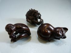 Three carved darkwood Netsukes depicting - Monkey, cat and a dragon