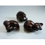 Three carved darkwood Netsukes depicting - Monkey, cat and a dragon