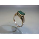 14ct emerald and diamond ring with central emerald flanked by diamond shoulder