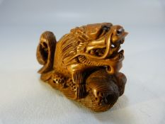 Carved wooden Netsuke of a dragon among water