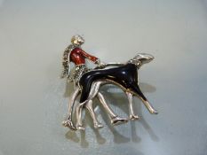 Silver art-deco style enamel-set brooch of a lady walking her dog