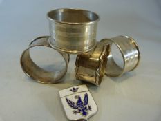 Four hallmarked silver napkin rings and an enamelled badge. approx weight -
