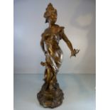 An Art Nouveau figural spelter gilt-painted, modelled as a femme fatale with flowing robes,