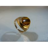 Gold coloured ring set with large Tigers eye stone. Gold metal unmarked.