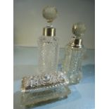 Two Cut glass silver collared scent bottles and a silver lidded dressing jar.