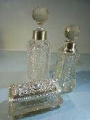 Two Cut glass silver collared scent bottles and a silver lidded dressing jar.