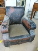 Leather fireside armchair with horsehair seat. The back with embossed crest. Castors marks