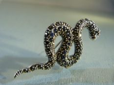 Silver snake brooch inset with sapphires and rubies