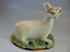 Yorkshire Pratt Ware recumbent ram / sheep. C.1820. The base decorated in ochre and black, with