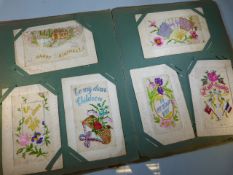 Album containing vintage and antique postcards along with a card backed sheet by Mabel Lucie