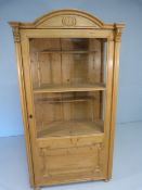 Antique pine glazed cabinet with single opening door. Fitted interior with raised shelf on