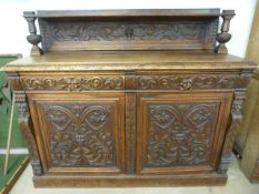 Green Man Gothic revival sideboard of small form. Below housing two drawers over two cupboards. Each