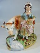 Staffordshire Prattware figure group of a cow and attendant milk maid. The naturalistic base