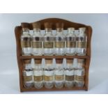 Set of glass and wooden topped spice jars with rack. (2 missing lids) (12 bottles in total)