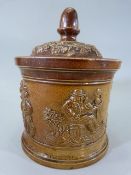 Brampton Pottery - Salt Glaze circular jar depicting various raised scenes of a man smoking a Pipe