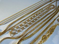 Collection of gold coloured necklaces of various styles and a gold coloured brooch.