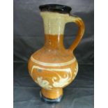 Slipware terracotta colour jug with red and cream decoration in the form of simplistic flowers,