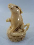 Japanese Netsuke of a Rodent seated on a plinth type base. Glass eyes with Red mark to top of tail.