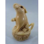 Japanese Netsuke of a Rodent seated on a plinth type base. Glass eyes with Red mark to top of tail.