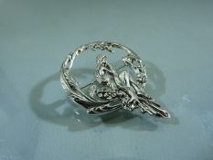 Art Nouveau style brooch of a seated lady surrounded by Floral Wreath. Marked Sterling