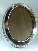 Hallmarked silver oval photo frame with beaded design.