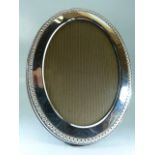 Hallmarked silver oval photo frame with beaded design.