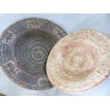 Two Large terracotta Pottery chargers. One with impressed 'Elephant' design to rim.