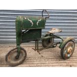 A tinplate pedal car in the form of a three wheeled tractor, possibly a John Deere.