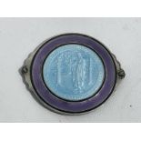 A purple and blue enamel St. Christopher badge.